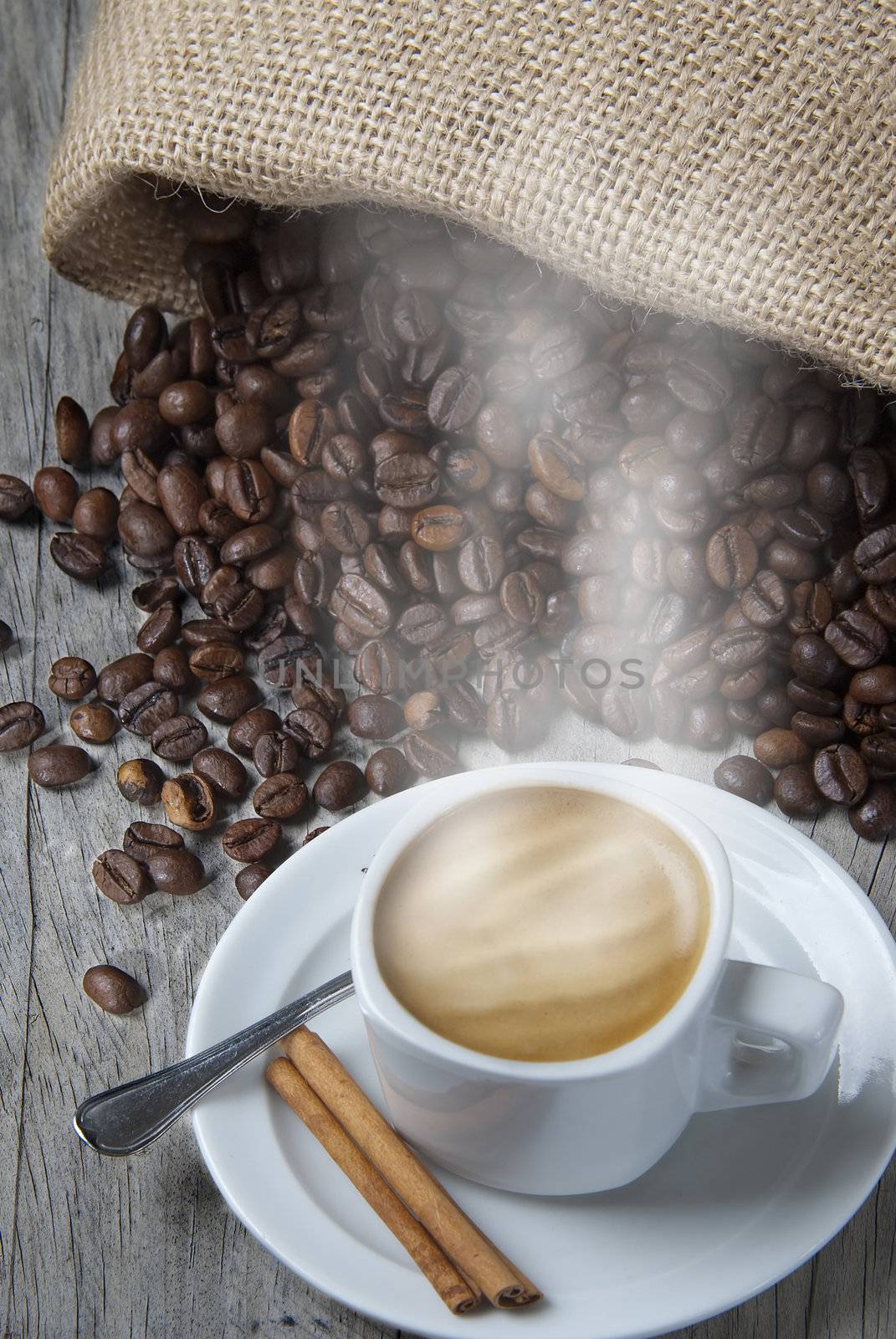 Still life about coffee with a delicious  espresso and some coffee beans and cinnamon.