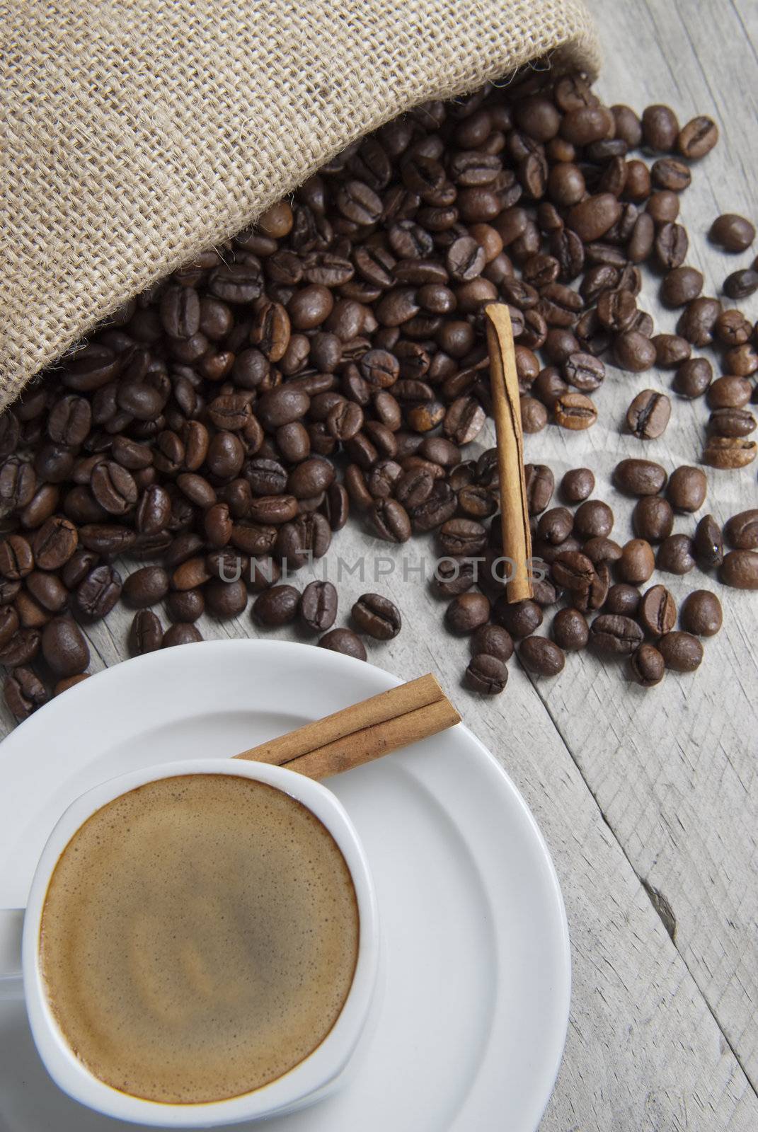 Still life about coffee with a delicious  espresso and some coffee beans and cinnamon.