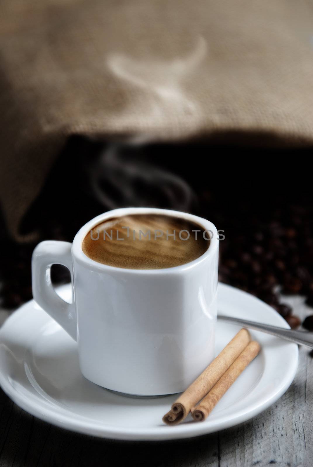 Still life about coffee with a delicious  espresso and some coffee beans and cinnamon.