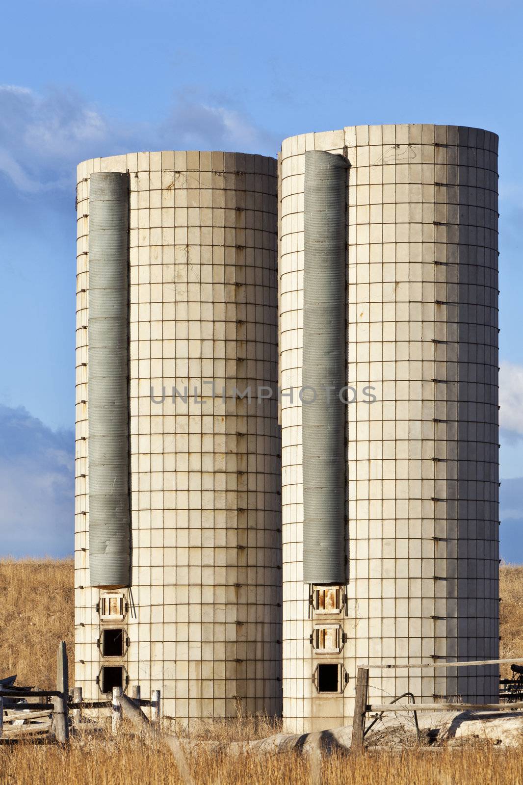 two old  cylindrical silos on an abandoned farm in eastern Colorado