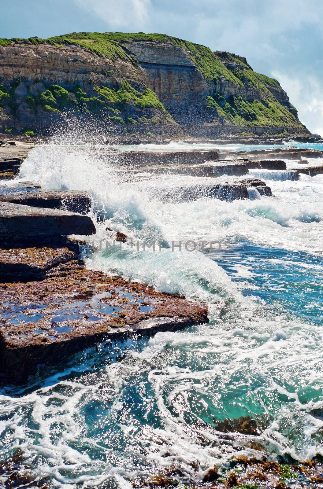 strong waves crashing onto rocks at the coast