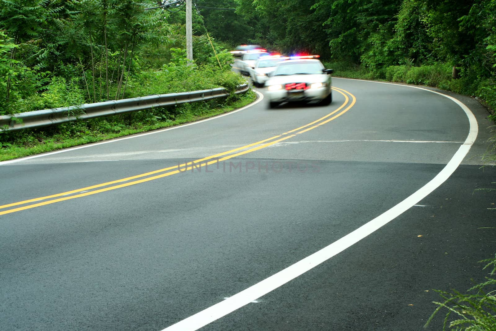 Police cars driving down the road