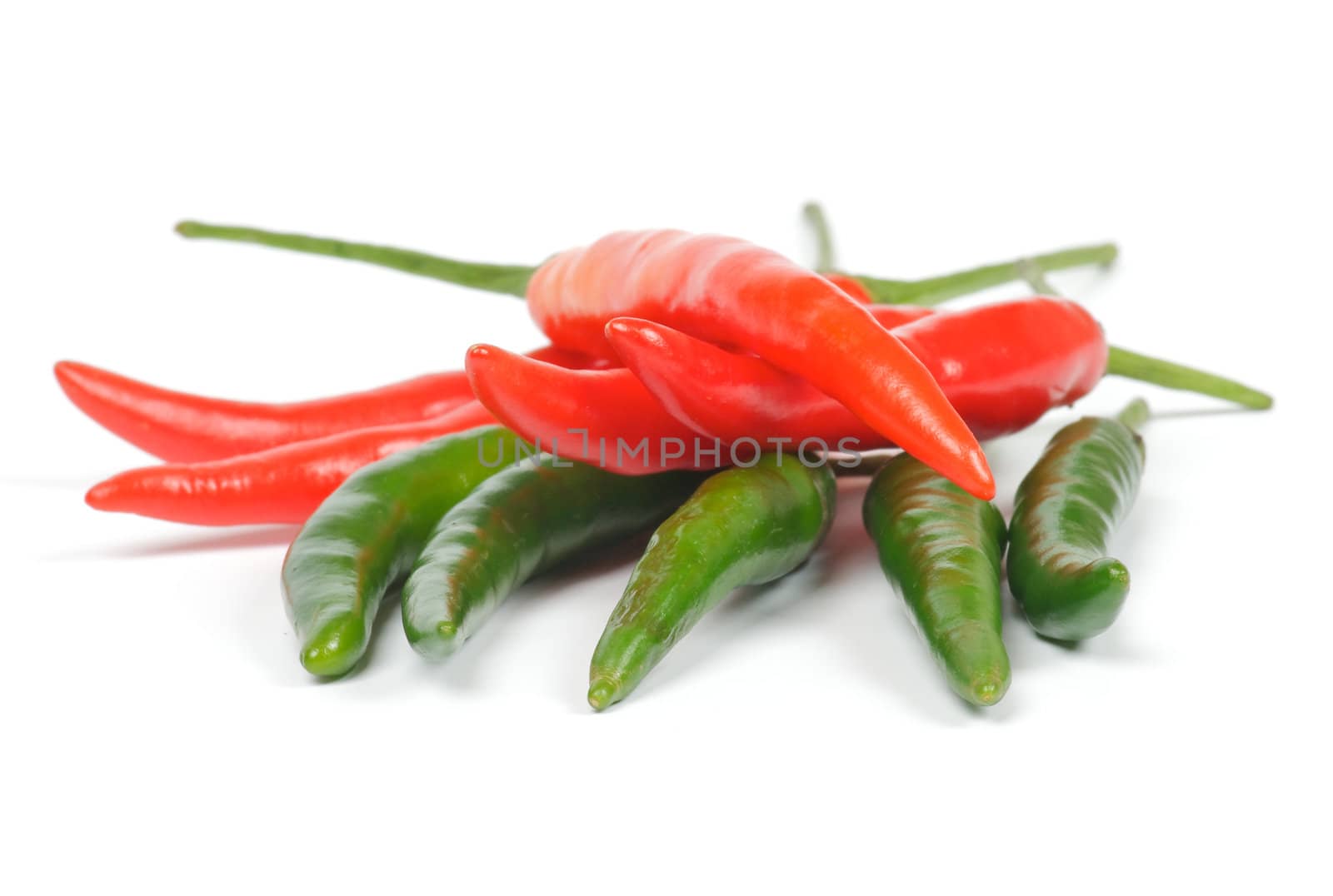 Arrangement of green and red chili peppers isolated in white background