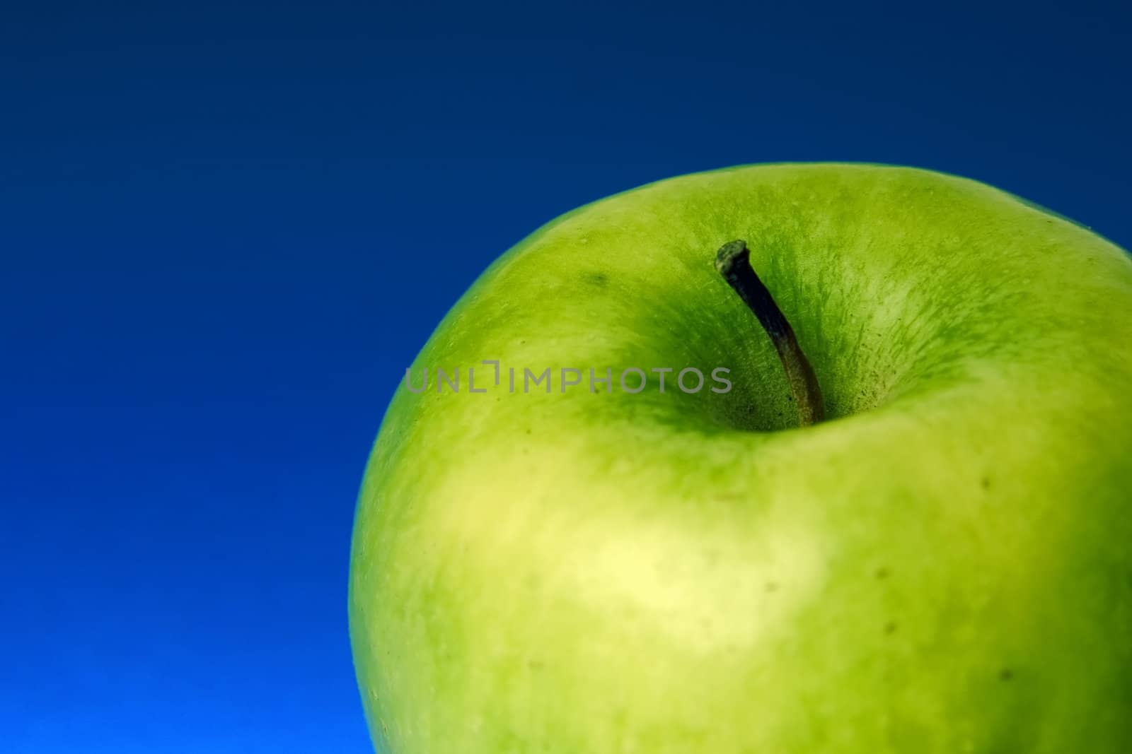 appetizing apple of green color on a blue background