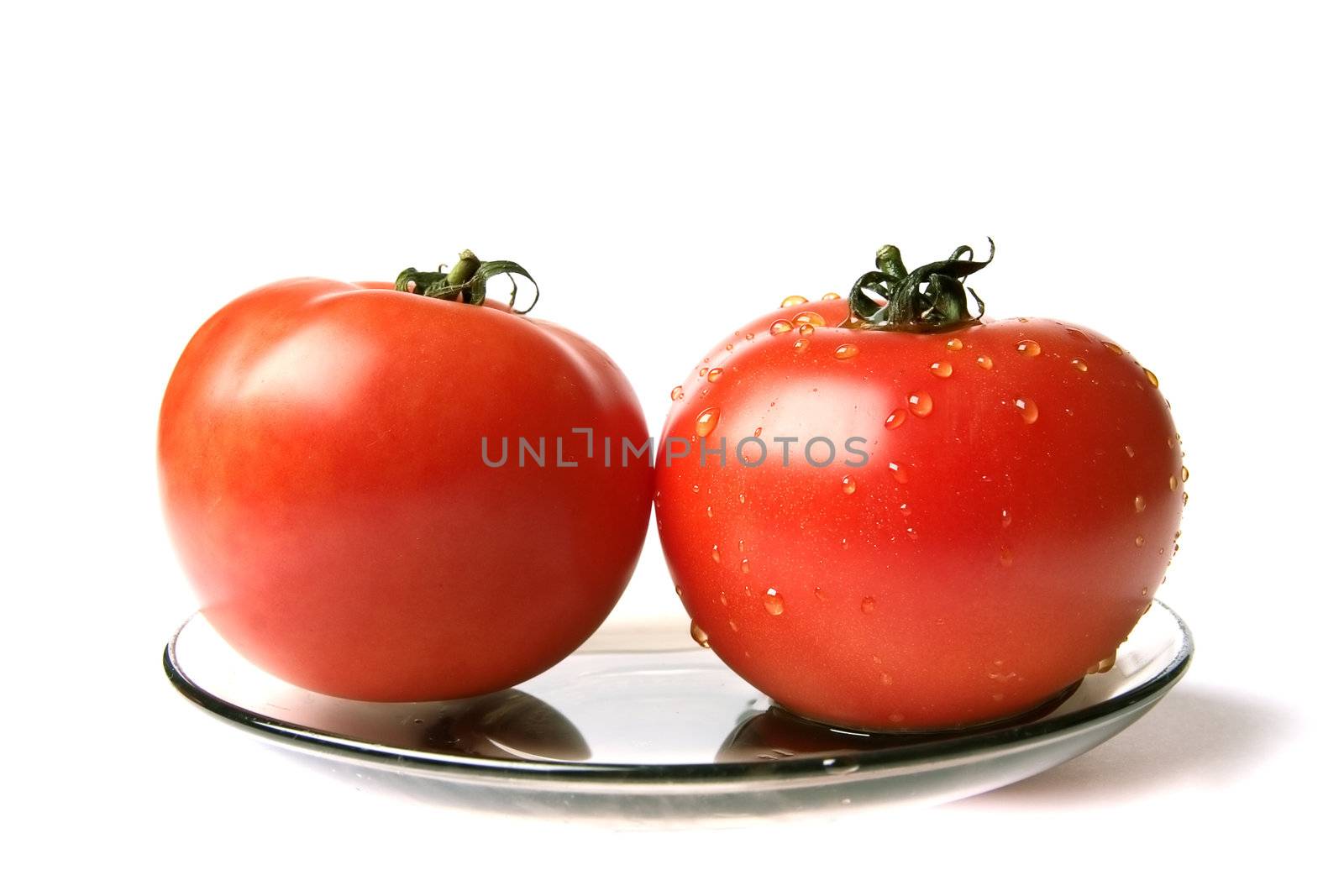 dry and wet tomatoes at the plate on a white background 