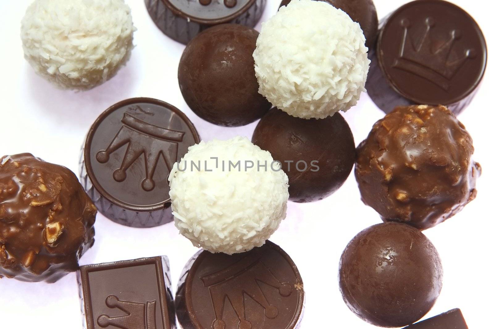 appetizing chocolate candies with a nut and coconut are sparse on a white background