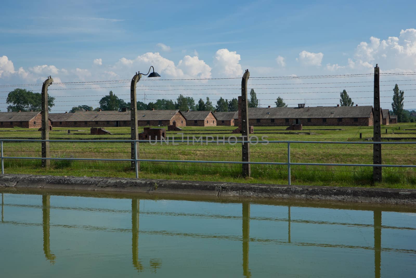 fence with huts in the background and blue sky