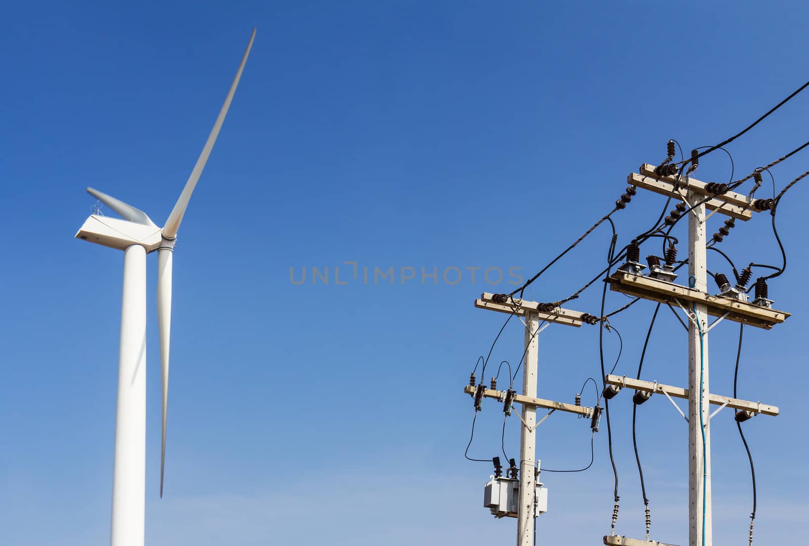 Wind energy turbine power station  and power lines transporting electricity.