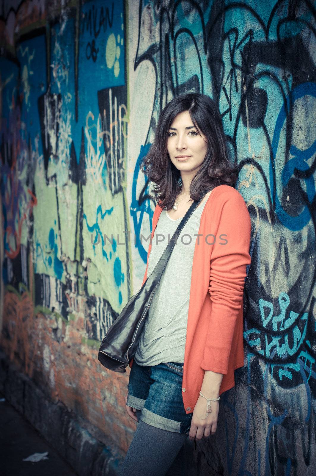 Beautiful stylish woman listening to music in the street 