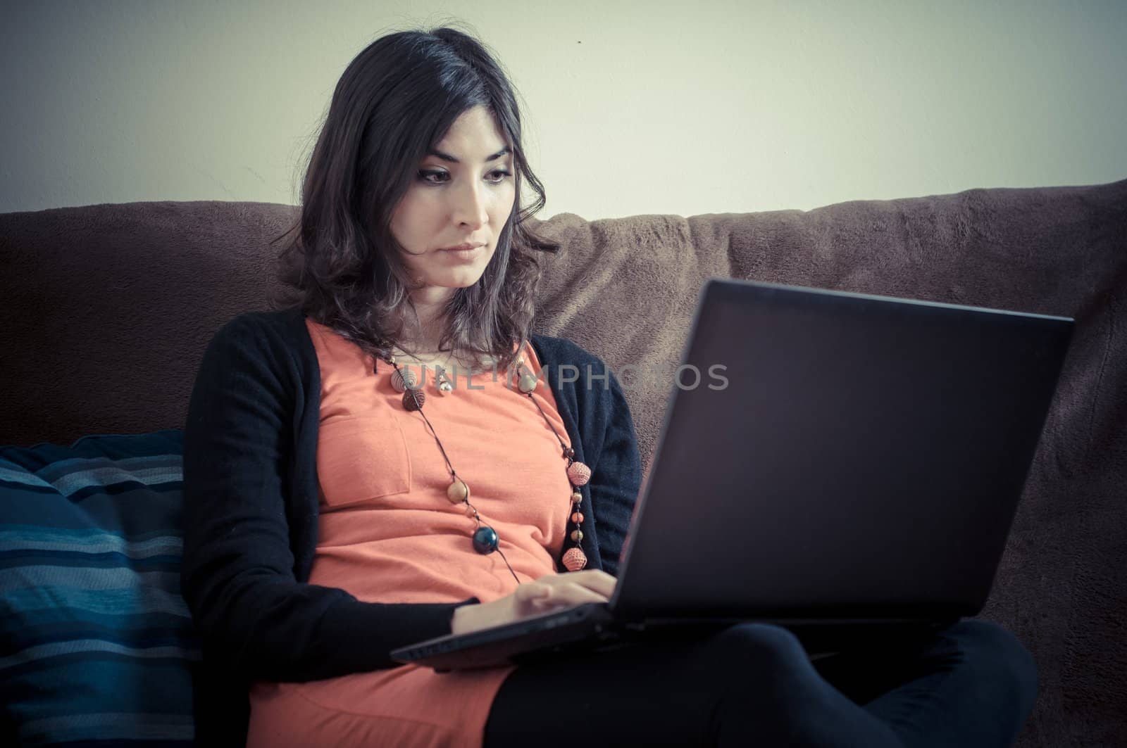 woman at home using notebook on couch