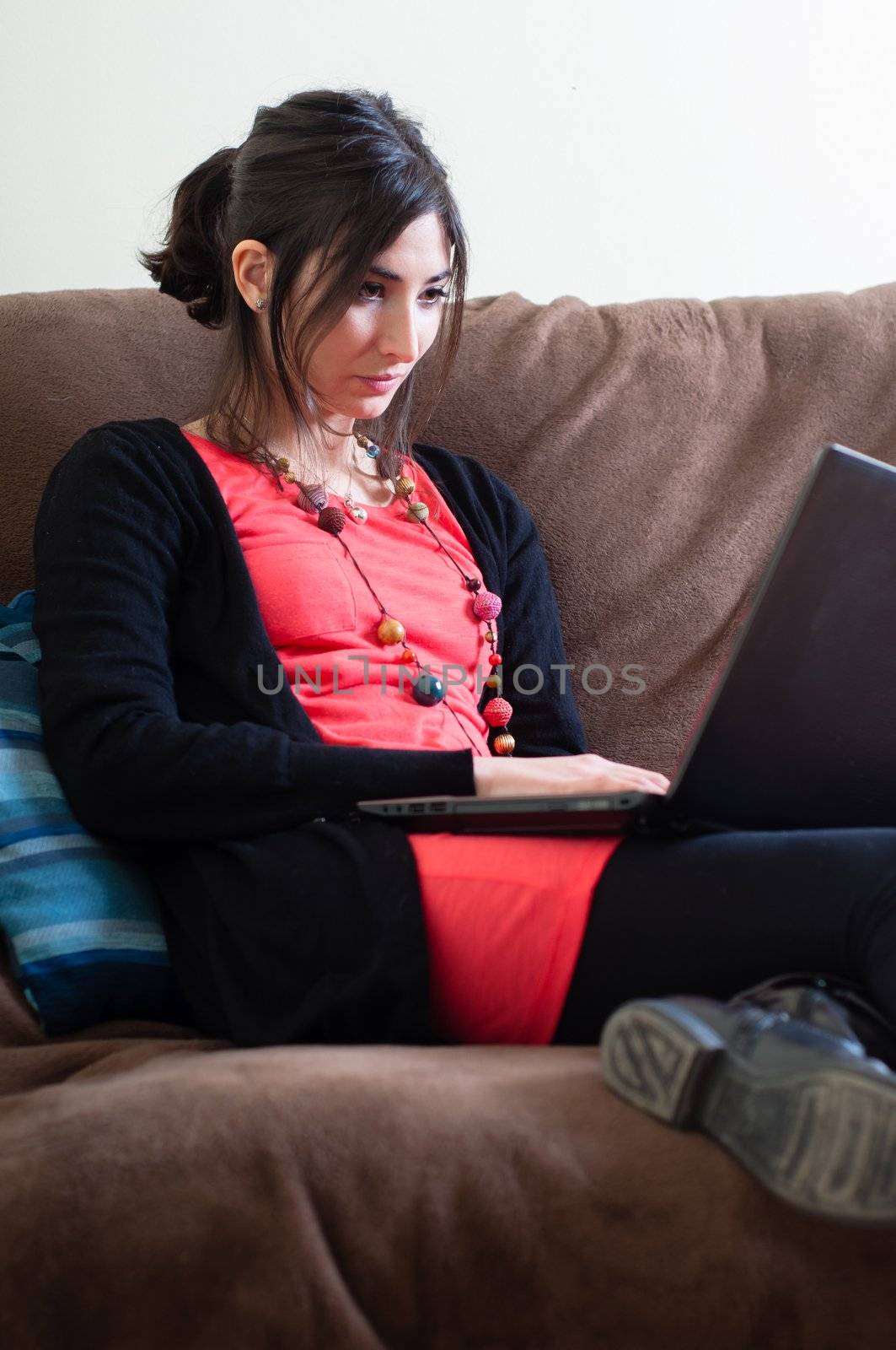 woman at home using notebook on couch