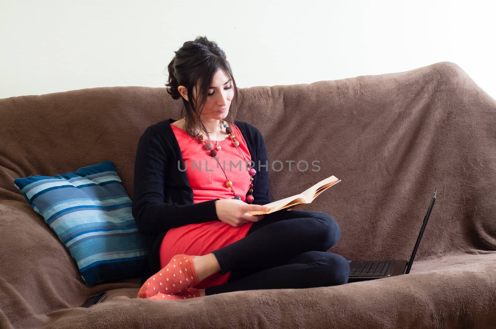 woman at home reading book on couch