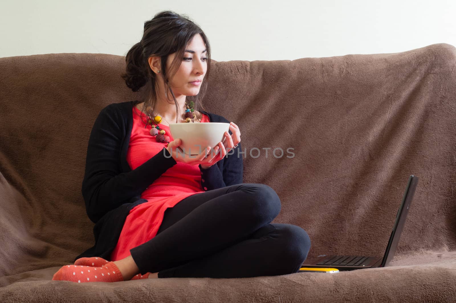 woman at home using notebook on couch