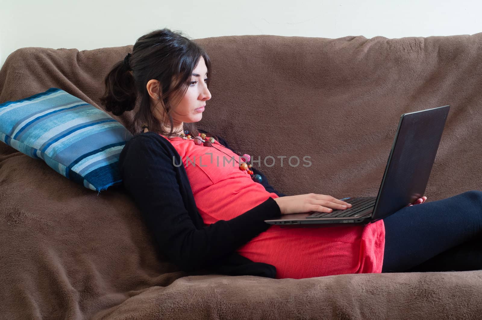 woman at home using notebook on couch