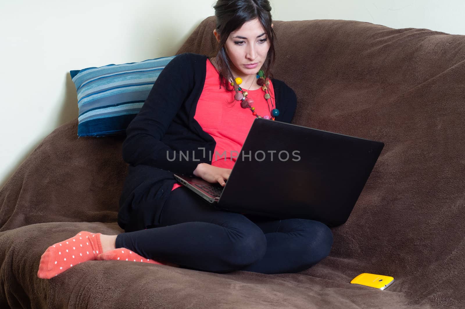 woman at home using notebook on couch