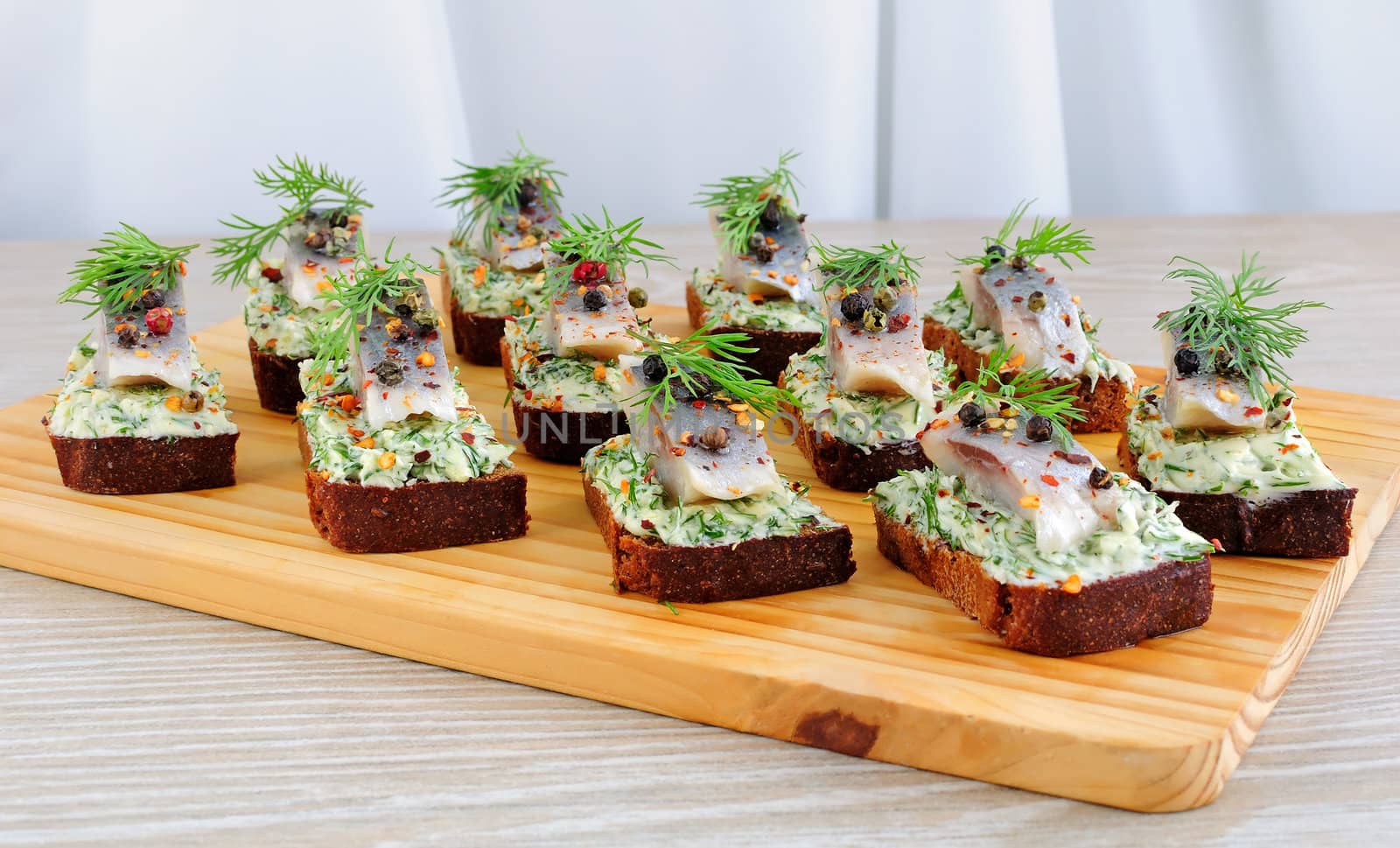 Snack rye bread with butter cream with herbs and spices herring