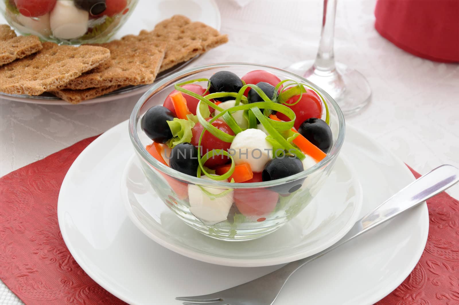 Salad of lettuce, cherry tomatoes, olives and mozzarella with pepper