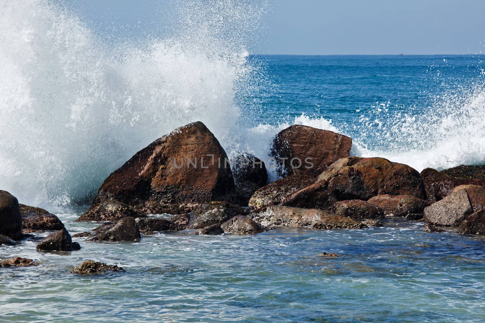 Waves breaking against the rocks by dimol