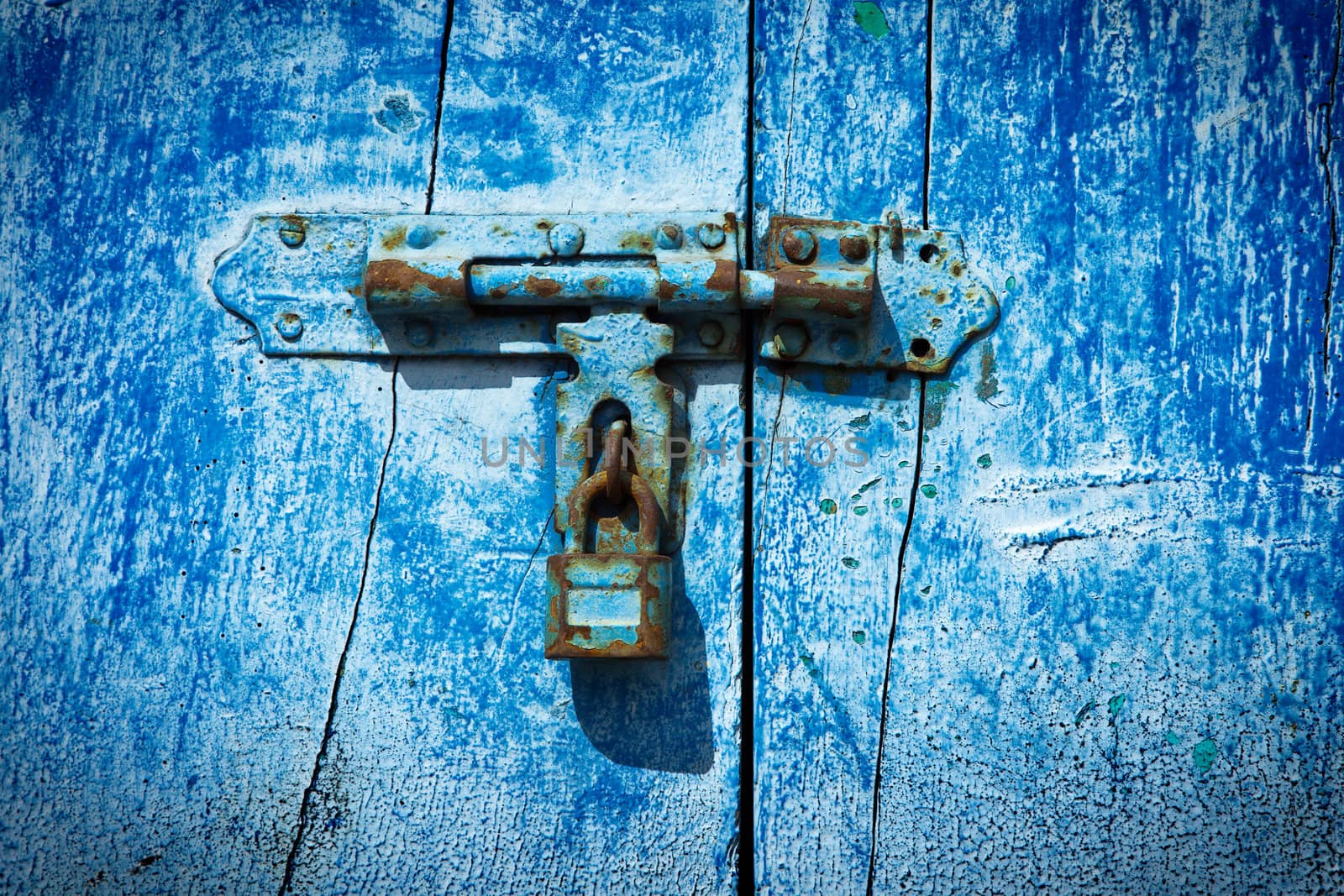 Old latch with padlock on the door