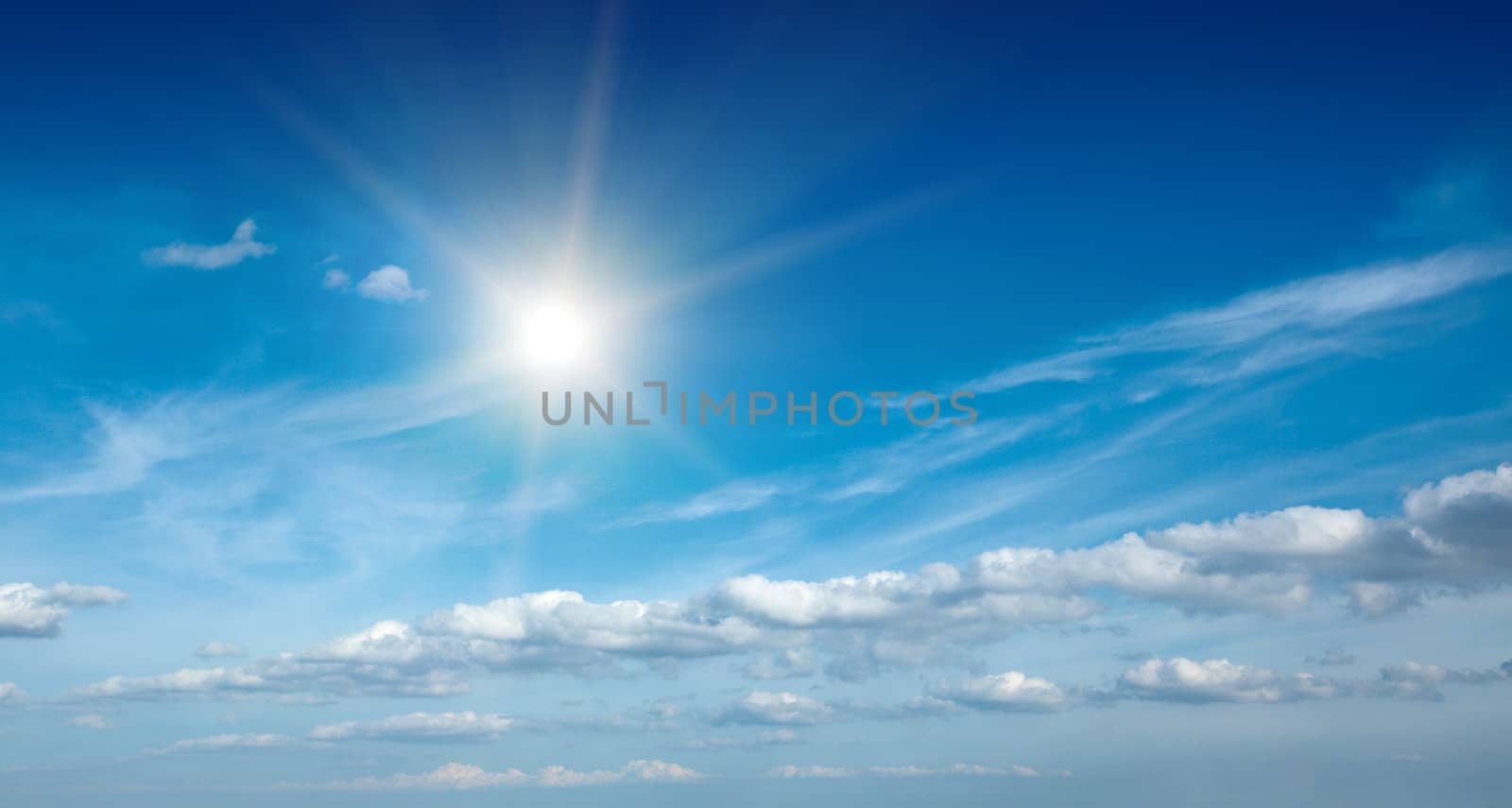 Sun with clouds in blue sky