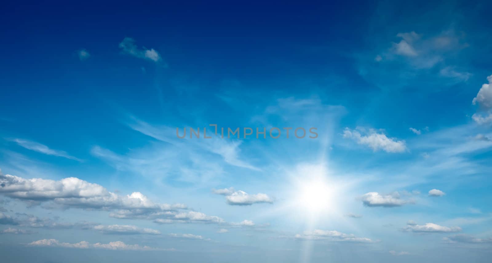 Sun with clouds in blue sky