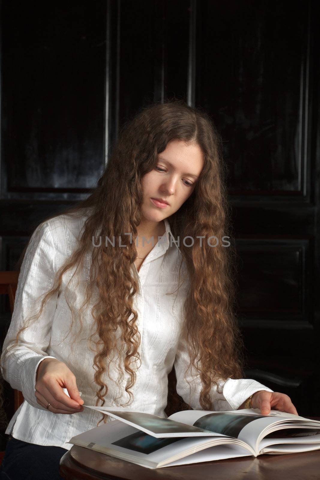 Young beautiful woman reading a book by dimol