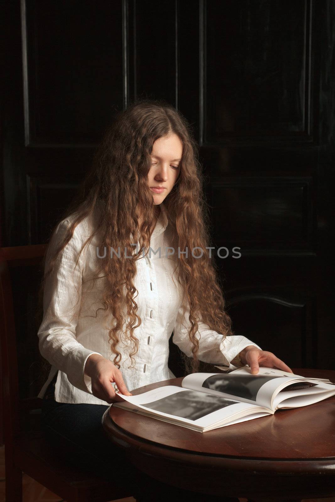 Young beautiful woman reading a book by dimol