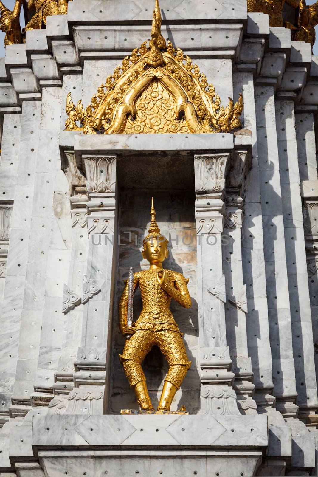 Gold guard on tower, in buddhist temple Wat Phi, Bangkok, Thailand