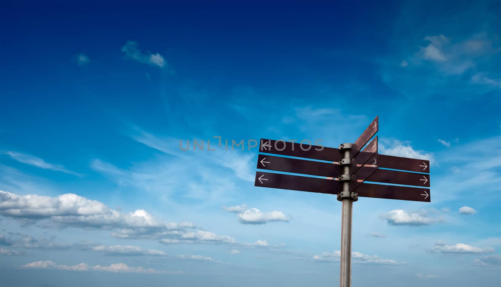 Blank signpost in sky with clouds