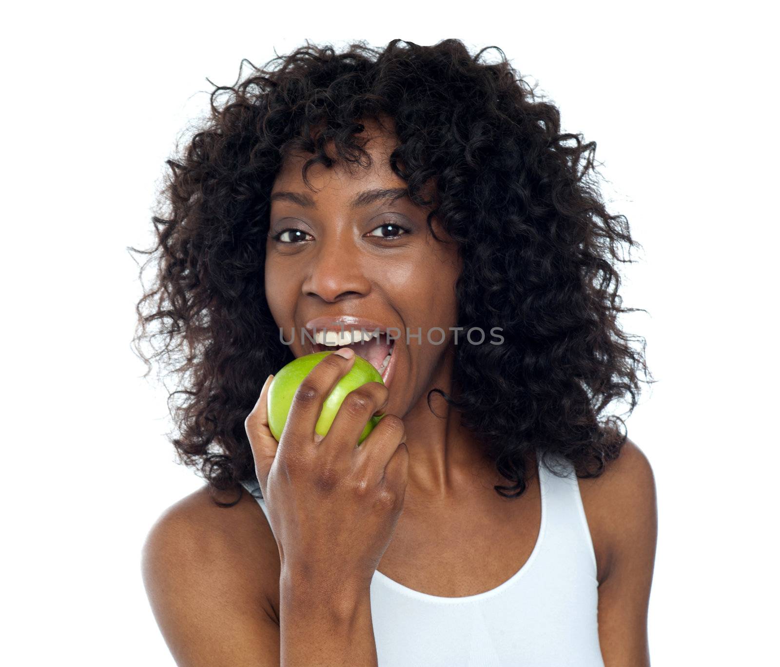 Sporty african fit woman eating fresh green apple