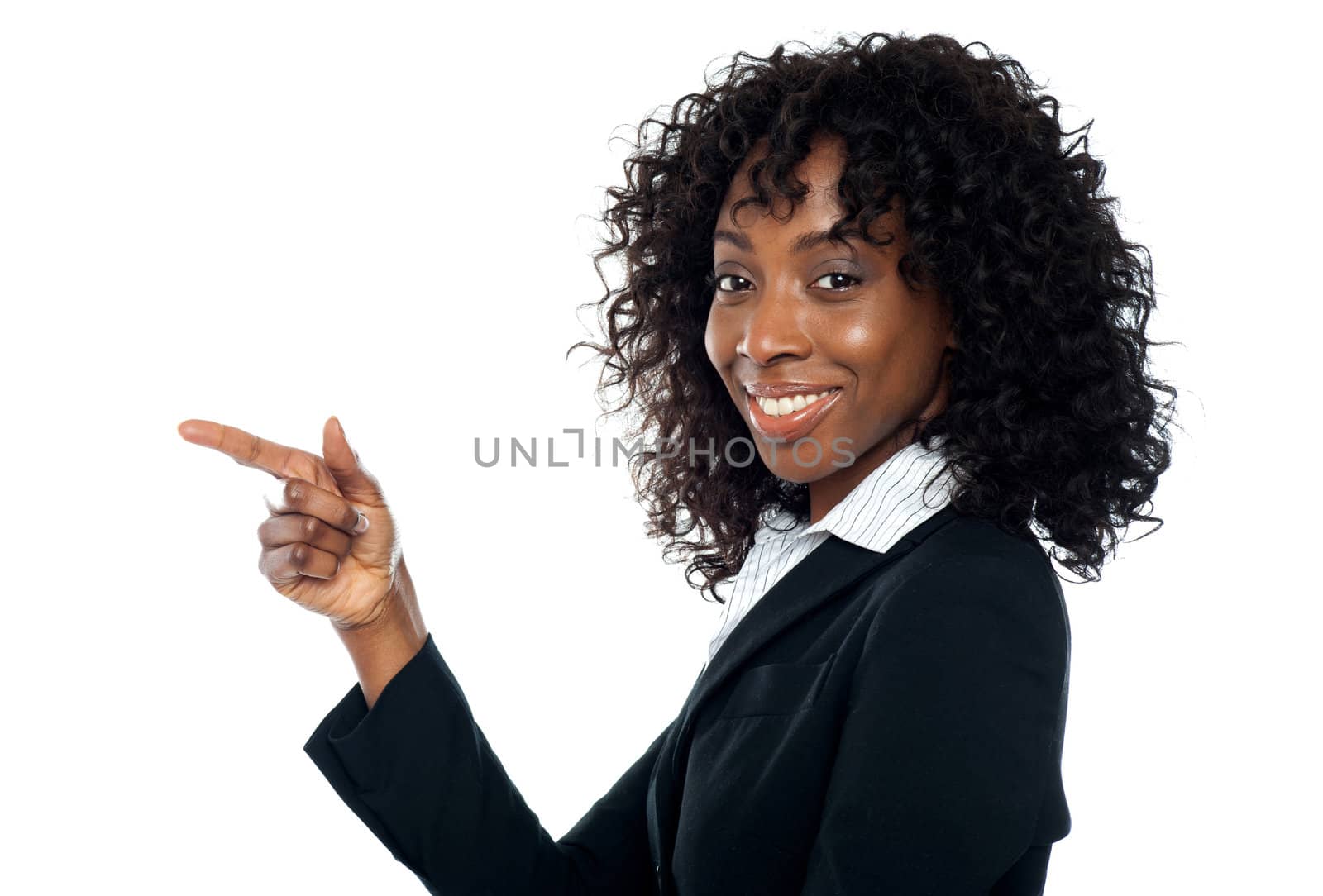 Corporate woman indicating towards copy space while looking at camera