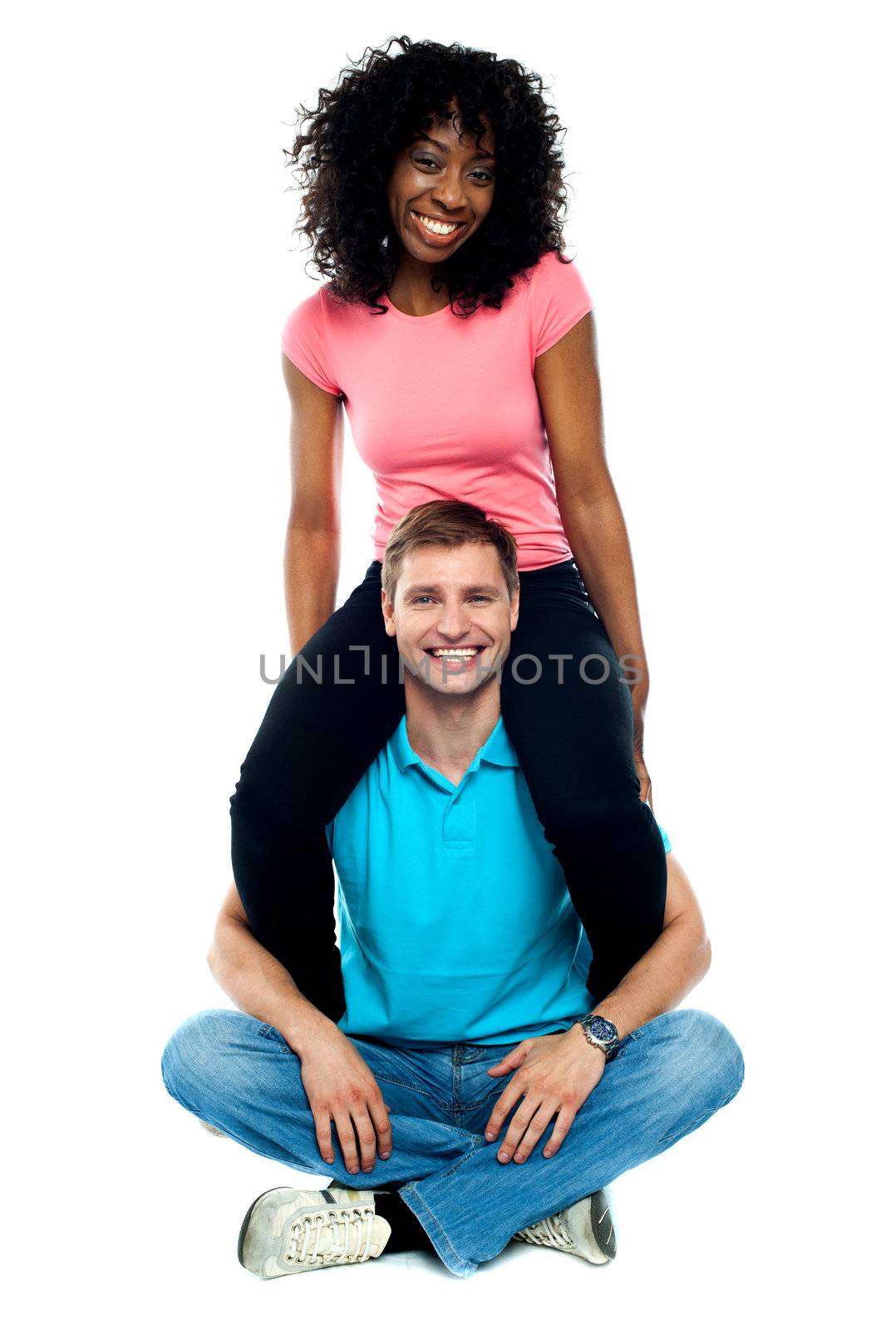 Girlfriend riding on her mans shoulder by stockyimages