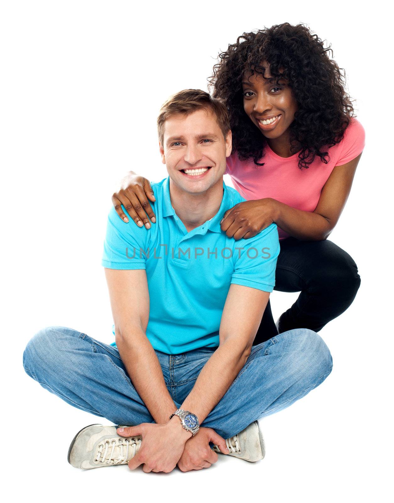 Love couple sitting on floor. Woman holding her man from behind
