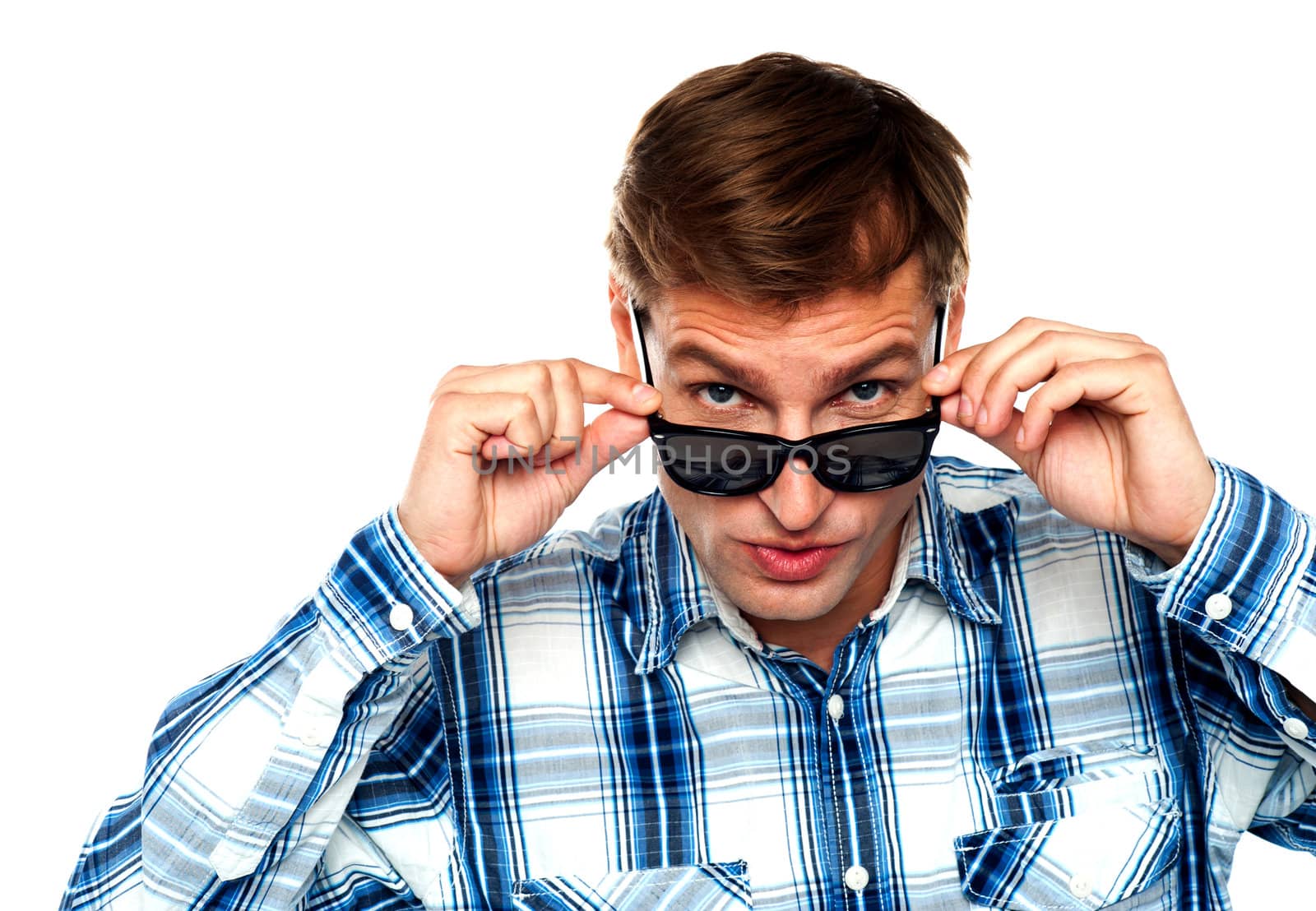 Confident young man peeping from behind the goggles right into camera