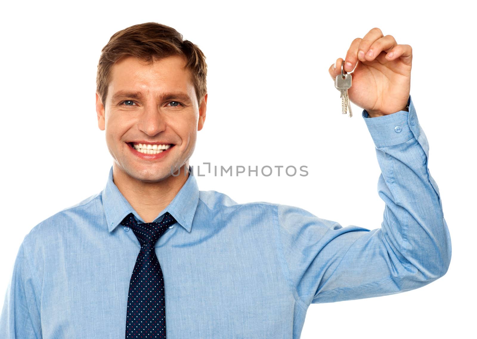 Portrait of smiling businessman holding keys isolated on white background