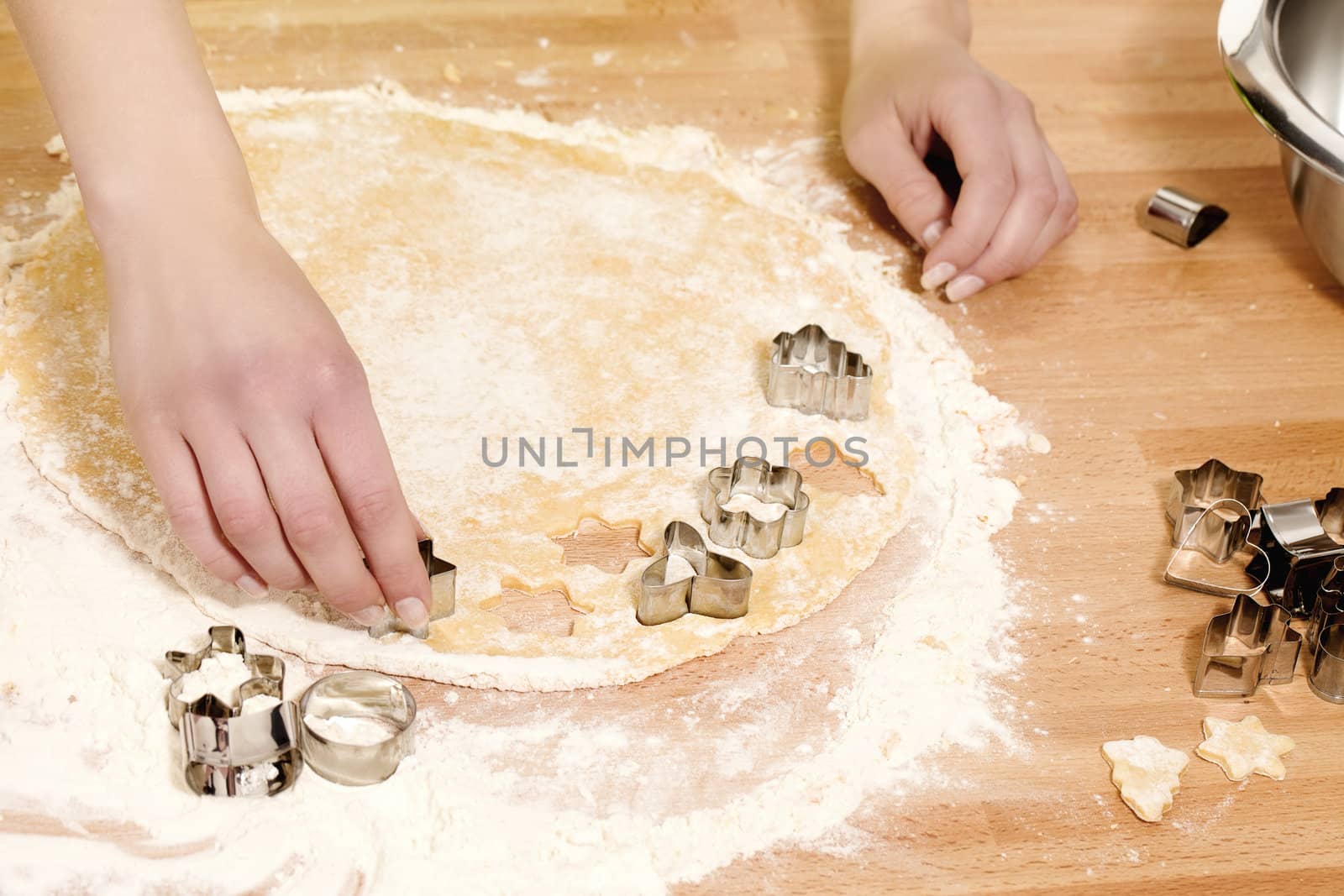 female hands pressing christmas molds in dough