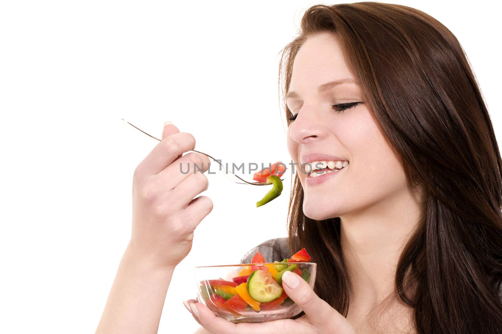 closeup of a young happy woman eating salad on white background