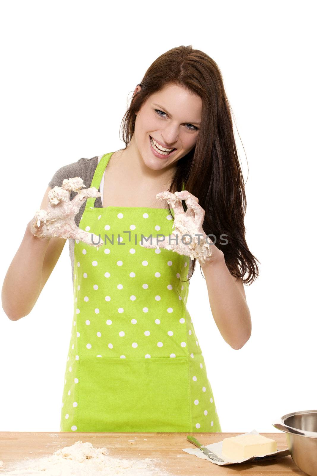young woman at baking forming claws with her messy dough covered hands on white background