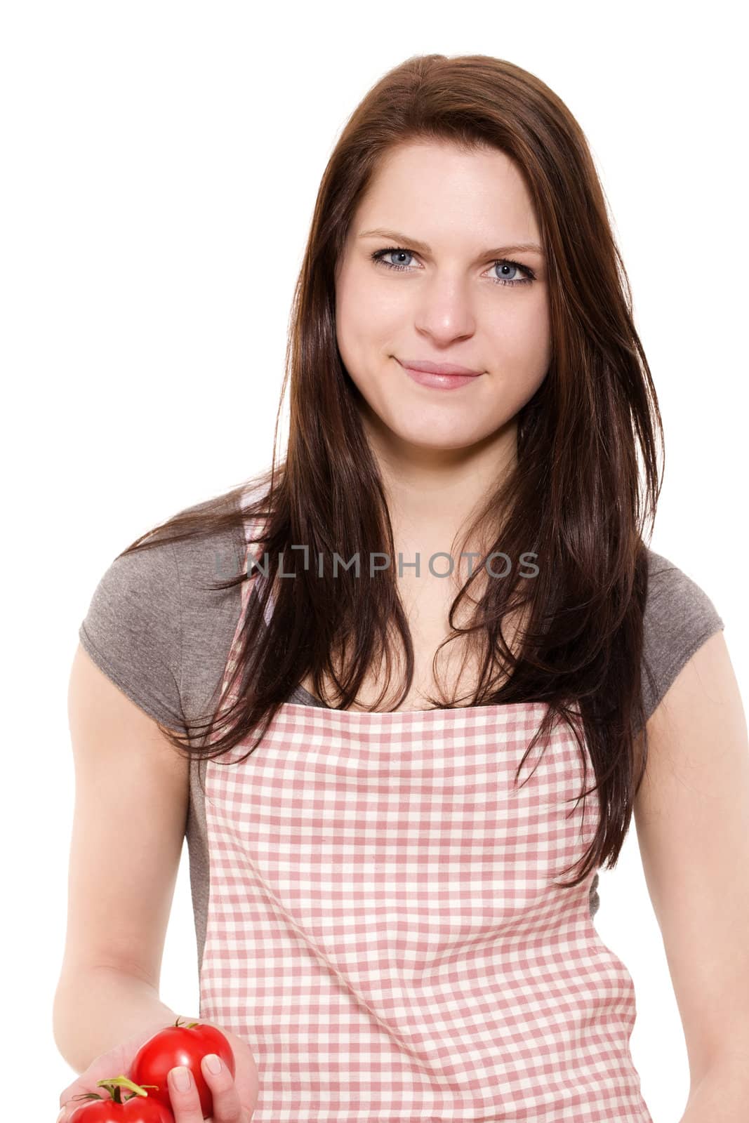 portrait of a smiling young woman with red apron holding tomatoes on white background