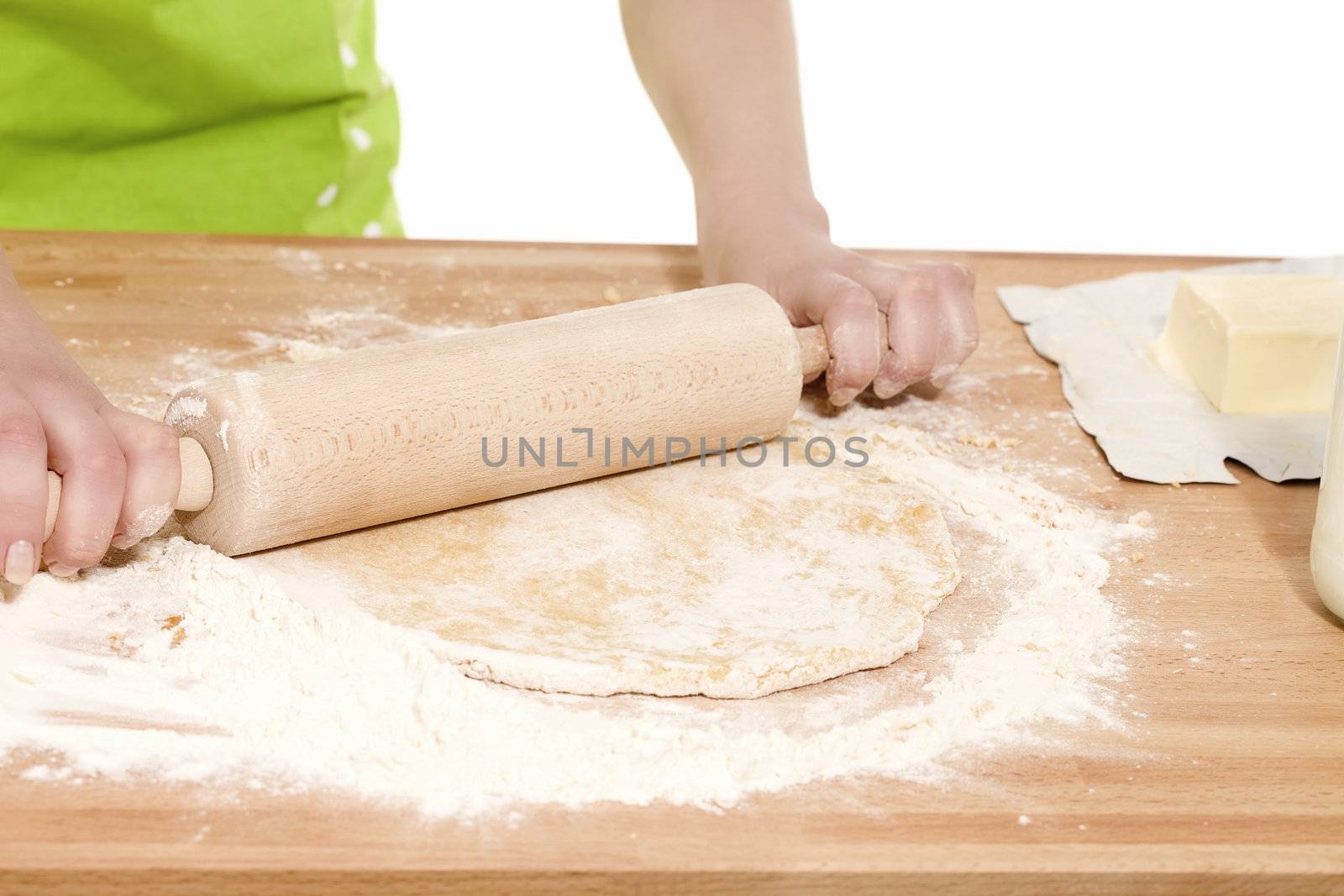 closeup of hands using rolling pin on dough