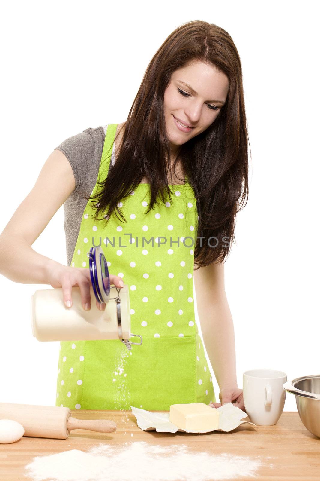 happy baking woman pouring flour on a table with white background