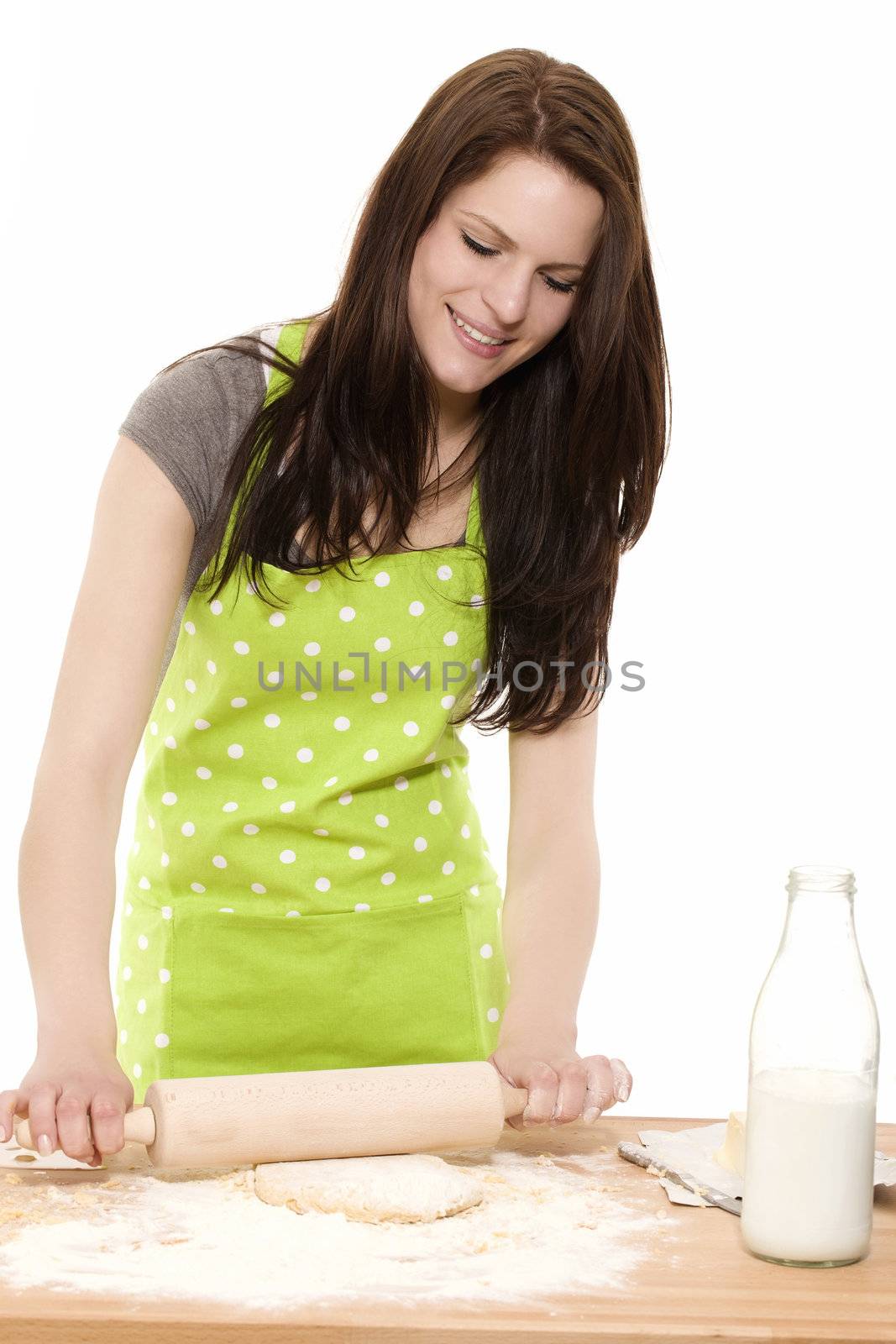 happy young woman baking using rolling pin on dough with white background
