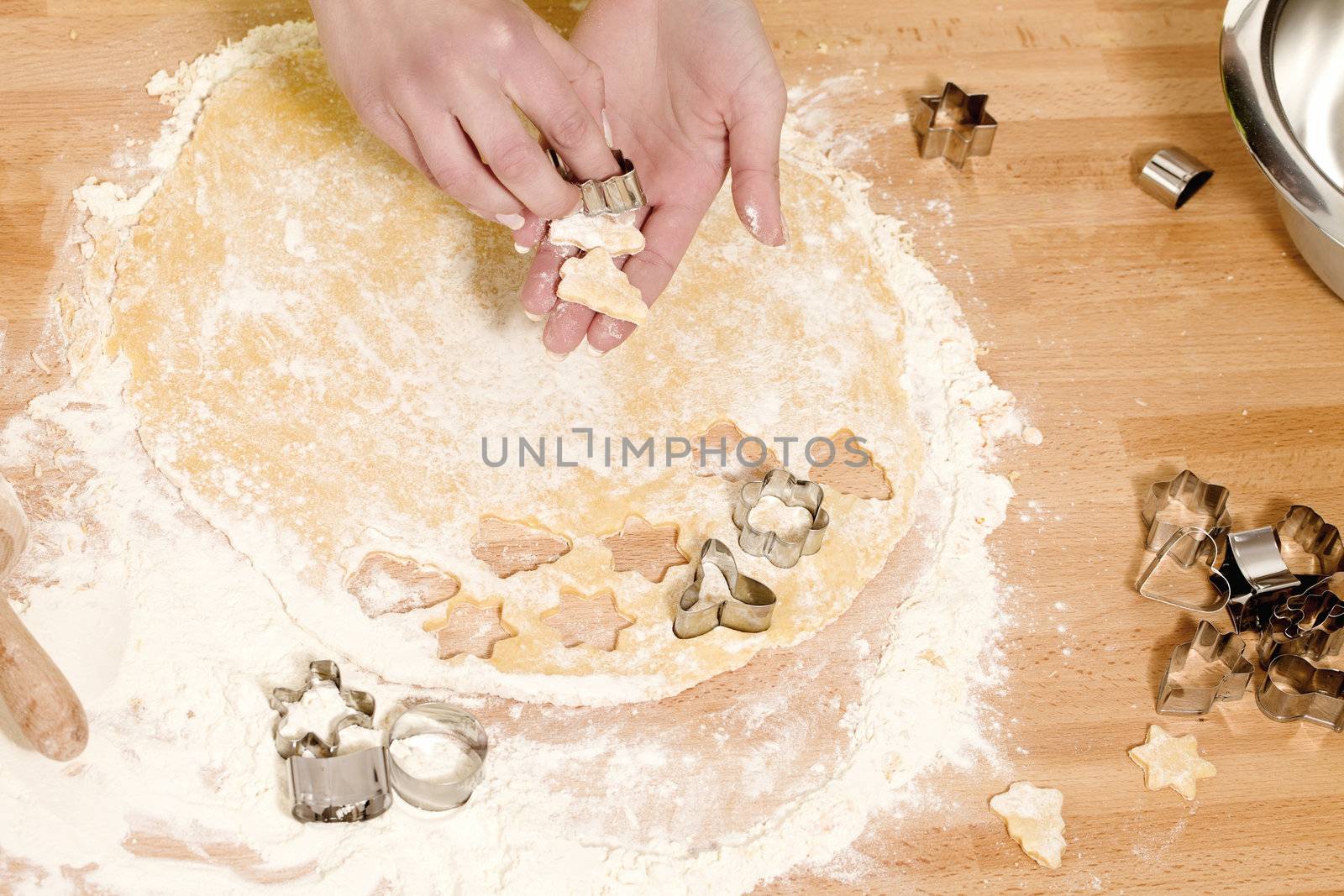 closeup of hands holding christmas formed dough for baking