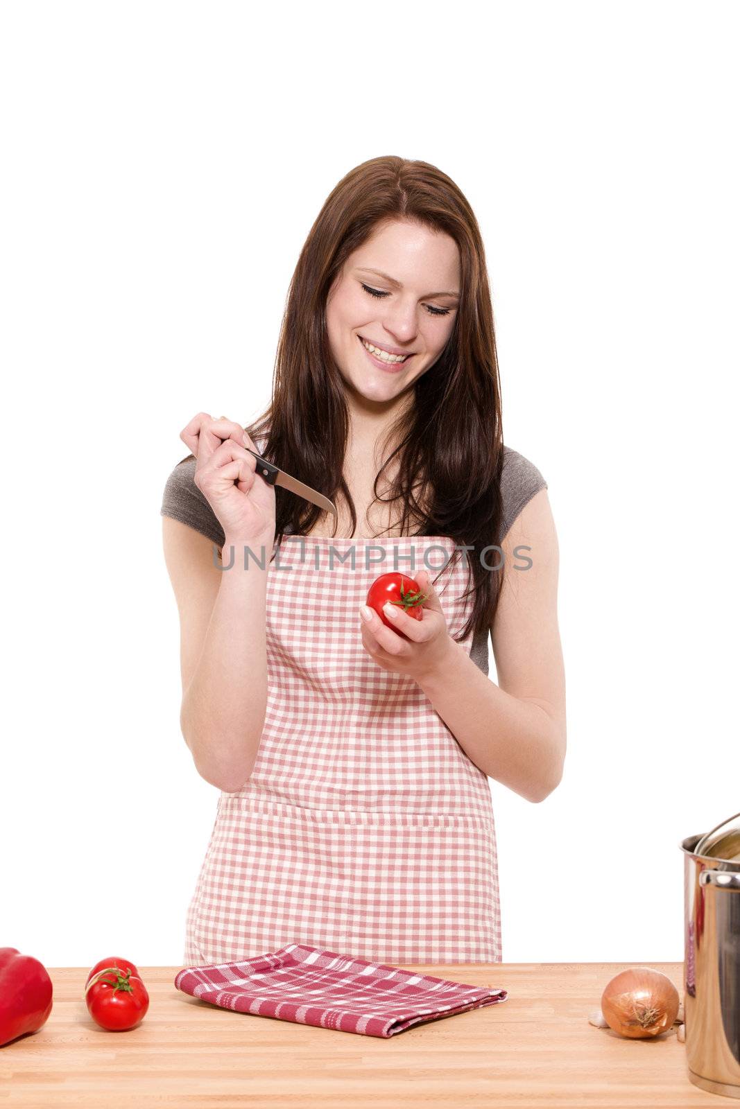 young happy woman about to cutting tomatoes on white background