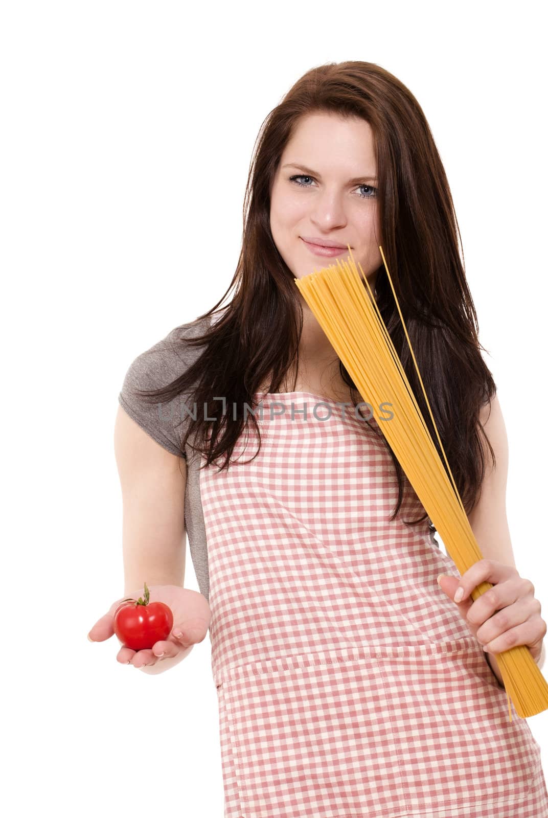 pretty young smiling woman holding spaghetti and tomato on white background