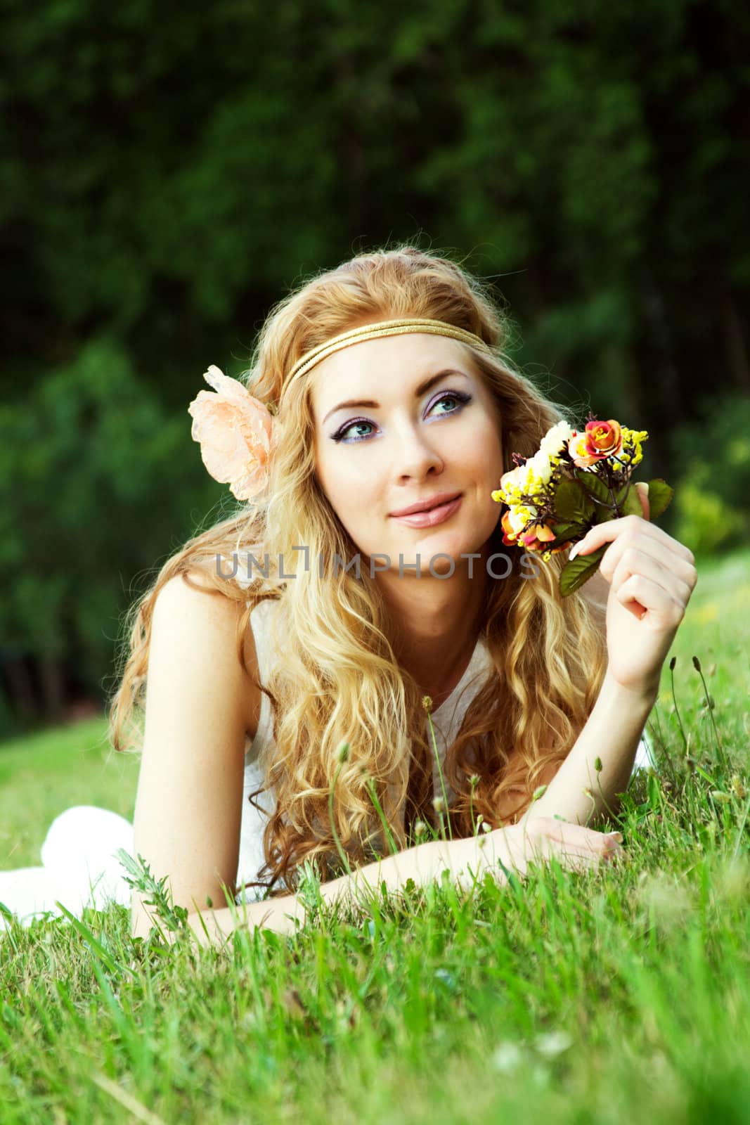 Romantic woman with rose lying on grass