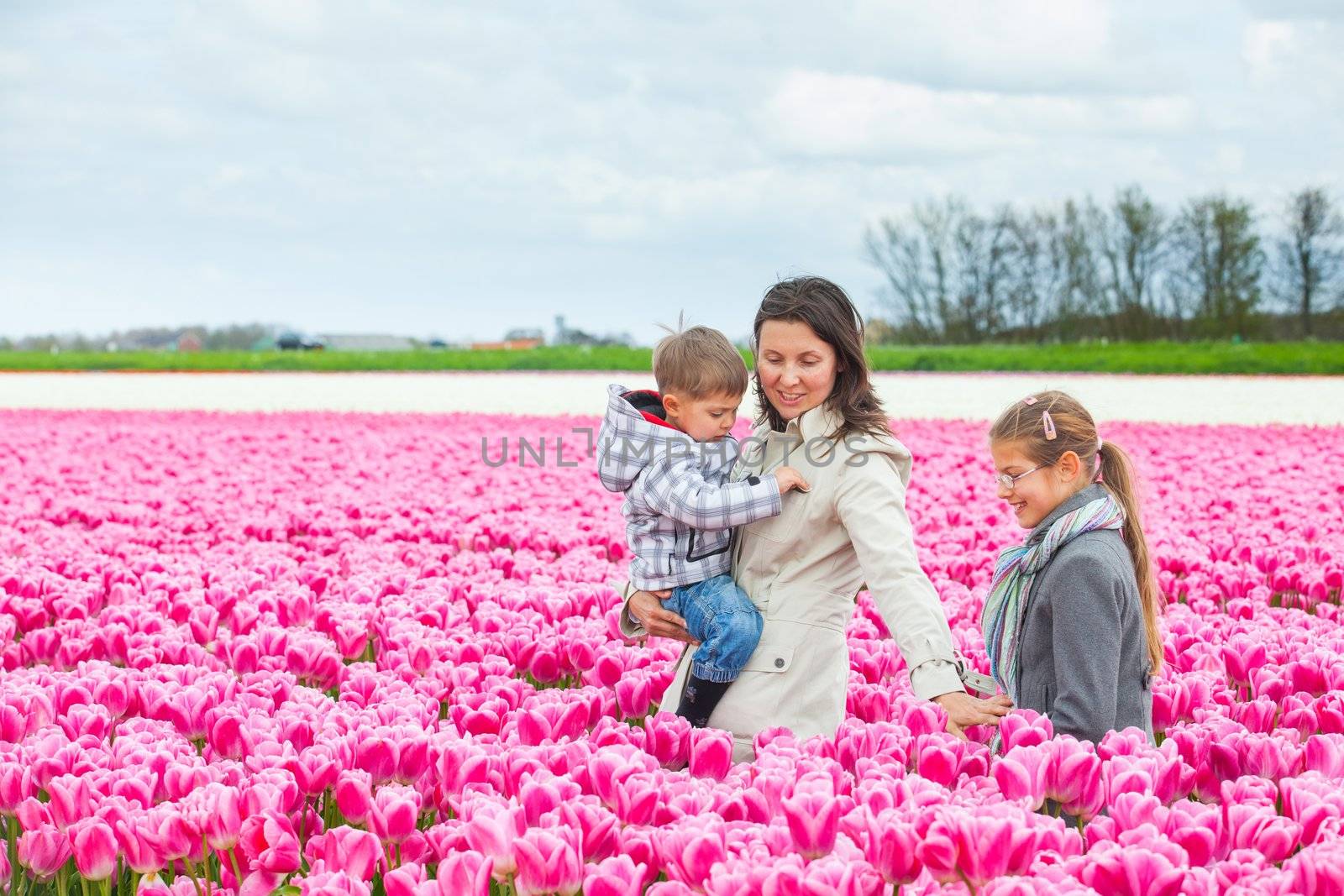 Mother with her child in tulips field by maxoliki