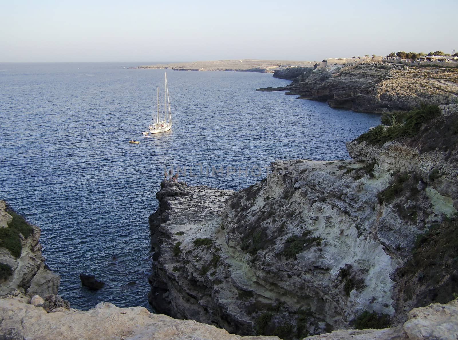 lampedusa cove with fishing and boat in the distance