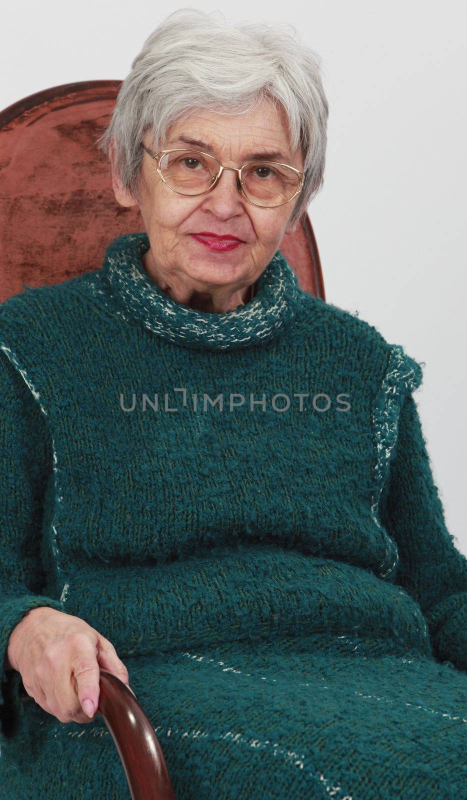 Portrait of an old woman against a grey background