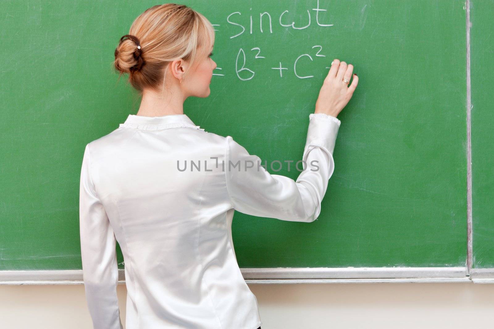 teacher writes on blackboard formula by nigerfoxy